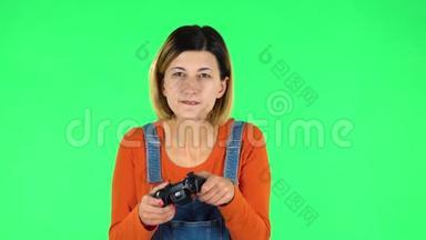 女孩玩电子游戏使用无线控制器与喜悦和失败。 绿色屏幕
